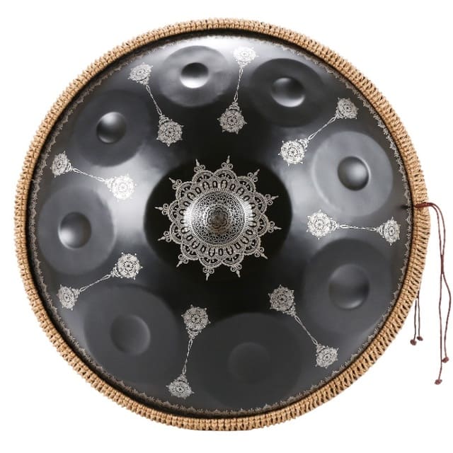 Handpan céleste noir posé sur un coussin, ambiance d'écoute