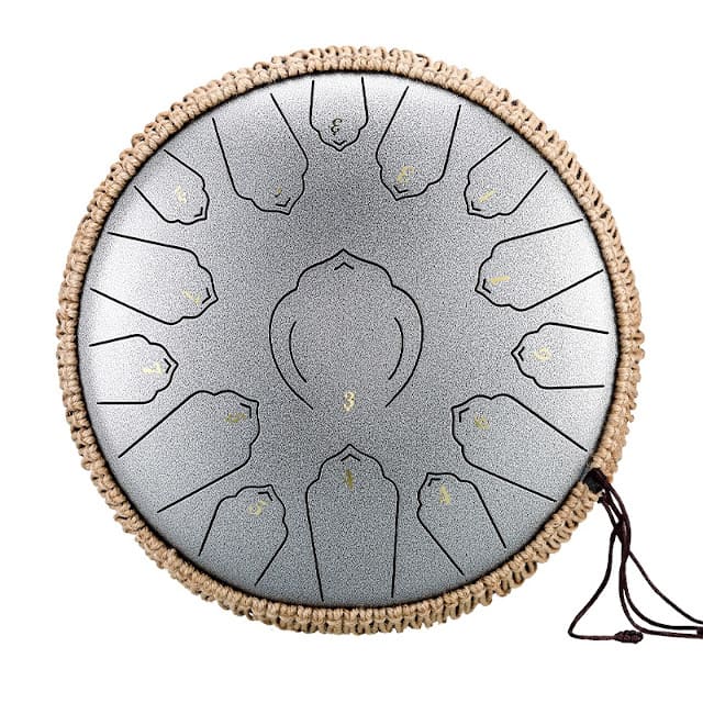 Tongue drum grand format posé sur un tapis, près d'un coussin